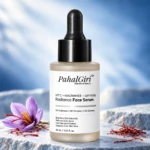 PahalGiri Radiance Face Serum 30 ml, grey-beige frosted bottle with black dropper and saffron on a pale blue stone surface